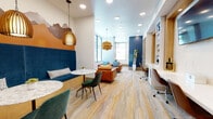 Located at 2420 Alcott St in Denver's LoHi neighborhood, this single-floor lounge space offers a thoughtfully designed interior that draws inspiration from Colorado's natural landscape. The room is immediately distinguished by a sweeping mountain mural rendered in warm terracotta and earthy tones that spans one wall, setting a regionally inspired tone throughout.

The space is organized into several distinct functional zones. A cozy banquette seating area features a tall navy blue velvet bench with marble-topped tables and pendant lights with woven rattan shades, providing an inviting nook for casual gatherings. Adjacent to it, a comfortable lounge area is anchored by rich cognac leather sofas and armchairs arranged around a glass-top coffee table, bathed in natural light from large floor-to-ceiling windows that frame views of mature trees outside.

A dedicated workspace runs along one wall, complete with a built-in desk and open shelving, making it well-suited for focused tasks. Light wood-toned luxury vinyl plank flooring ties all zones together, complementing the space's warm color palette of navy, orange, and natural wood tones. Recessed ceiling lighting and statement pendant fixtures ensure the space is well-lit throughout. Curated artwork, including a framed mixed-media piece and botanical prints, adds a refined, welcoming ambiance to the overall design.