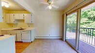 This two-bedroom, one-bathroom unit in Westland, Michigan offers a well-organized single-floor layout with a functional and straightforward design. The living room is generously sized, featuring neutral carpet, baseboard heating, a ceiling fan, and a wall-mounted air conditioning unit. Large sliding glass doors open directly onto a private balcony that overlooks lush, mature trees, bringing in abundant natural light and pleasant outdoor views. An additional window further brightens the space.

The galley-style kitchen is efficiently arranged with white cabinetry extending to the ceiling on both sides, providing ample storage. It includes a dishwasher, electric range, refrigerator, and a sink with a window view, along with hardwood flooring that contrasts with the carpeted living areas.

Both bedrooms are carpeted and equipped with baseboard heating. One bedroom features a sliding glass door to the balcony and a ceiling fan, while the second bedroom includes a standard window and a reach-in closet with built-in shelving. The full bathroom is clean and functional, featuring a tiled tub-shower surround, a single-sink vanity with white cabinetry, and tile flooring throughout.