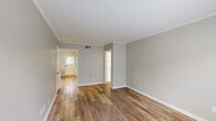 This single-story home in Memphis, TN offers four bedrooms and two bathrooms thoughtfully arranged across a compact, efficient floor plan. Throughout the home, warm hardwood-style luxury vinyl flooring flows seamlessly from room to room, complemented by soft gray walls, crisp white crown molding, and clean white baseboards that give the space a fresh, cohesive look.

The bedrooms are well-proportioned and filled with natural light from multiple windows fitted with white blinds. The spacious primary bedroom features two windows offering outdoor views, while the additional bedrooms each include at least one window and direct door access, making them functional and bright.

The galley-style kitchen is a standout feature, outfitted with gray shaker cabinetry, stainless steel appliances including a refrigerator and range, a dishwasher, and light stone-look countertops. A window above the sink and a rear door bring in natural light and provide convenient exterior access.

The two bathrooms are distinctly styled. The full bathroom showcases classic white subway tile surrounding the tub and shower, paired with gold-tone hardware and marble-look tile flooring. The second bathroom is clean and minimal, featuring a white vanity with brushed nickel fixtures and a framed mirror. A central hallway connects all rooms, ensuring a smooth and logical flow throughout the home.