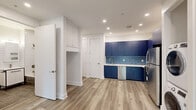 This thoughtfully designed one-bedroom, one-bathroom unit at 715 Park Ave in East Orange, NJ offers a fresh, modern aesthetic throughout. Light wood-look flooring flows seamlessly across every room, complemented by crisp white walls, clean baseboards, and recessed lighting that keeps the space feeling bright and well-appointed.

The open kitchen and living area serves as the heart of the unit, making a bold statement with deep navy blue cabinetry that extends floor to ceiling. A coordinating blue hexagonal tile backsplash adds texture, while stainless steel appliances — including a refrigerator, gas range, over-the-range microwave, and dishwasher — complete the functional, stylish setup. A stacked washer and dryer unit is conveniently integrated into the kitchen area, adding valuable in-unit laundry.

The bedroom is a calm, well-proportioned retreat featuring a window with outdoor views, a closet, and a wall-mounted mini-split system for individual climate control. The hallway connects the living spaces efficiently and includes additional storage.

The bathroom is finished with full-height white subway tile walls, large-format taupe floor and tub surround tiles, a sleek vanity with black metal accents, and a soaking tub with shower — delivering a clean, contemporary look with quality finishes throughout.