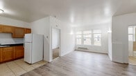 Located at 4901 South Drexel Boulevard in Chicago's Woodlawn neighborhood, this one-bedroom, one-bathroom unit offers a practical and well-organized layout across a single floor. The open-concept living and dining area is bright and airy, featuring light hardwood-style flooring, white walls, and a large window that invites natural light while offering views of the surrounding neighborhood. A baseboard heating unit ensures year-round comfort. The kitchen is efficiently designed with warm-toned wooden cabinetry, dark countertops, tile flooring, and includes a full suite of white appliances — a refrigerator, electric range with hood, and sink. The bedroom is a comfortable, carpeted retreat with its own window, baseboard heating, and a dedicated closet with a hanging rod for convenient storage. An additional closet in the main living area provides extra storage space. The bathroom features tile flooring, a tiled tub surround, a window for ventilation, and classic white fixtures. Clean white walls and consistent finishes throughout the unit give the space a cohesive, move-in-ready feel well-suited for individuals or couples seeking a functional home in Chicago.