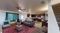 Located at 9800 Mesa Linda St in Hesperia, California, this two-story home offers a functional and comfortable layout across two levels. The main floor showcases an open-concept living and kitchen area, where rich dark mahogany cabinetry pairs with stainless steel appliances — including a gas range, over-the-range microwave, and a side-by-side refrigerator with water dispenser. Light wood-look flooring runs throughout the kitchen and dining space, while the living area features a ceiling fan and easy access to a front entry door. A bathroom on this level includes a dark wood vanity with granite-style countertop and wood-look flooring. The upper level hosts a spacious primary bedroom with a walk-in closet, ceiling fan, and large windows dressed in elegant drape panels that allow natural light to filter in. An additional bedroom on this floor offers a built-in sliding-door closet and carpeted flooring. A dedicated laundry area is conveniently located on the upper level, complete with a full-size washer and dryer. A second living space on the upper floor provides additional room for relaxation or entertainment, also featuring a ceiling fan. The home includes an attached garage with an automatic door opener, offering practical storage and parking. Throughout, the home presents a welcoming and livable atmosphere suited for everyday comfort.