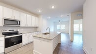 Located at 3730 Dupont Avenue in Jacksonville, FL, this well-appointed one-bedroom, one-bathroom unit offers a thoughtfully designed open-concept floor plan. The kitchen serves as a central highlight, featuring a large granite-topped island with an undermount sink, crisp white shaker cabinetry extending to the ceiling, a subway tile backsplash, and a full suite of stainless steel appliances including a French door refrigerator, electric range, and microwave. Wood-style flooring flows seamlessly from the kitchen into the open living area, which is brightened by recessed lighting and a ceiling fan. The spacious bedroom offers a ceiling fan, natural light through double windows with blinds, and access to a generously sized walk-in closet with wire shelving. The bathroom includes a soaking tub with tiled surround, granite vanity, wood-style flooring, and accessibility grab bars. A dedicated utility room adds practical functionality. The unit's clean, neutral palette of whites and warm tones creates a bright, cohesive ambiance throughout. A dedicated closet and utility room round out the efficient and functional layout of this move-in-ready space.