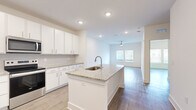 Located at 3730 Dupont Avenue in Jacksonville, FL, this well-appointed one-bedroom, one-bathroom unit offers a thoughtfully designed open-concept floor plan. The kitchen serves as a central highlight, featuring a large granite-topped island with an undermount sink, crisp white shaker cabinetry extending to the ceiling, a subway tile backsplash, and a full suite of stainless steel appliances including a French door refrigerator, electric range, and microwave. Wood-style flooring flows seamlessly from the kitchen into the open living area, which is brightened by recessed lighting and a ceiling fan. The spacious bedroom offers a ceiling fan, natural light through double windows with blinds, and access to a generously sized walk-in closet with wire shelving. The bathroom includes a soaking tub with tiled surround, granite vanity, wood-style flooring, and accessibility grab bars. A dedicated utility room adds practical functionality. The unit's clean, neutral palette of whites and warm tones creates a bright, cohesive ambiance throughout. A dedicated closet and utility room round out the efficient and functional layout of this move-in-ready space.
