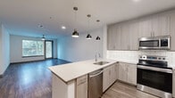 Located on Race St in Fort Worth, TX, this well-appointed 2-bedroom, 1-bathroom residence offers a thoughtfully designed single-floor layout with modern finishes throughout. The open-concept kitchen and living area forms the heart of the home, featuring light gray cabinetry, white quartz countertops, a classic subway tile backsplash, and a full suite of stainless steel appliances including a range, microwave, dishwasher, and refrigerator. A peninsula with pendant lighting anchors the kitchen, flowing seamlessly into the living area, which is finished with warm wood-tone flooring and large windows that invite natural light. The spacious primary bedroom features wood-look flooring, a ceiling fan, and a large window with outdoor views. The second bedroom is carpeted and also includes a ceiling fan, offering a cozy retreat. A dedicated walk-in closet provides ample storage with built-in wire shelving. The bathroom is finished with a wide vanity, white quartz countertop, light wood cabinetry, and a large framed mirror with modern lighting. Throughout the residence, clean lines and a neutral color palette create a cohesive, contemporary ambiance ideal for comfortable everyday living.