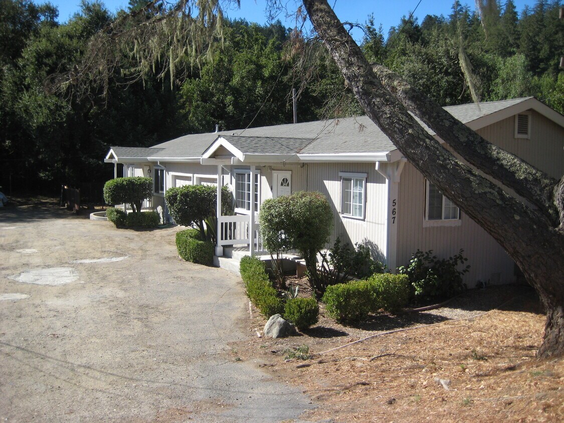 Front porches of duplex. Garages are in between. Forested backdrop behind. - 567 San Geronimo Valley Dr