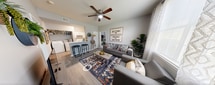 This charming 620 square foot apartment in Baton Rouge, LA offers a well-designed living space with two bedrooms and two bathrooms. The interior showcases a modern aesthetic with a neutral color palette, complemented by pops of color in artwork and decor. The living room features a ceiling fan, large windows with sheer curtains, and a comfortable seating area anchored by a vibrant area rug. The kitchen, though compact, is efficiently designed with white appliances and cabinetry. Both bedrooms are tastefully decorated, with the primary bedroom measuring 120 square feet. The bathrooms are bright and updated, featuring large mirrors and ample lighting. Throughout the apartment, wood-look flooring adds warmth and durability. Thoughtful touches like wall-mounted planters, artistic wall pieces, and stylish light fixtures elevate the overall ambiance. The layout maximizes the available space, creating a cozy yet functional home that balances style and practicality.