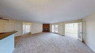 Located at 1147 W Grand River Ave in Williamston, Michigan, this single-story, 3-bedroom, 2-bathroom home offers a practical and comfortable layout across a well-proportioned floor plan. The living room serves as the heart of the home, highlighted by a striking full-height brick fireplace with a wood mantel and glass doors, paired with plush carpeted flooring and a sliding glass door that opens to an outdoor deck, allowing natural light to fill the space. The kitchen is thoughtfully designed with warm honey-toned wood cabinetry, dark granite-style countertops, tile flooring, a double-basin sink, and a peninsula breakfast bar that connects to the living area. A full suite of appliances is included. The primary bedroom features soft carpeting and a ceiling fan with light fixture, while the additional bedrooms are carpeted and bright, each with access to natural light. Both bathrooms are finished with granite-style tile surround tub-shower combinations and matching tile flooring, offering a cohesive and clean aesthetic. A dedicated in-unit laundry area with overhead cabinetry adds everyday convenience. Neutral tones throughout create a versatile backdrop suited to a variety of interior styles.