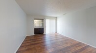 Located at 803 Flame Cir in San Antonio, TX, this single-floor 2-bedroom, 2-bathroom home offers a practical and comfortable layout. The open-concept kitchen and living area serves as the heart of the home, featuring rich wood-look flooring that extends through the main living spaces. The kitchen is well-equipped with dark cabinetry, a black appliance suite including a refrigerator and electric range, light countertops, and a pass-through bar that connects seamlessly to the living area. The living room benefits from a sliding glass door that invites natural light and provides outdoor access. Each bedroom is carpeted for comfort and includes a ceiling fan with light fixture. The spacious primary bedroom offers generous proportions and is complemented by a dedicated walk-in closet with built-in shelving and hanging rods for ample storage. The second bedroom also features a walk-in closet. Both bathrooms are finished with white tile tub-shower combinations and chrome fixtures, maintaining a clean, neutral aesthetic. Textured ceilings are consistent throughout the home, adding a classic residential touch. The overall design is straightforward and functional, making efficient use of the available space.