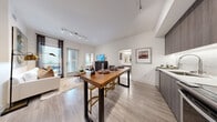 Located at 1140 Harrison St in San Francisco's SoMa neighborhood, this well-appointed two-bedroom, two-bathroom residence offers a thoughtfully designed single-level layout with modern finishes throughout. The open-concept living and dining area is anchored by wood-look flooring, track lighting, and large windows that invite abundant natural light and views of the palm-lined streetscape. A sliding glass door connects the living space to an outdoor area, enhancing the sense of openness. The contemporary kitchen is outfitted with dark wood cabinetry, a linear tile backsplash, white quartz countertops, stainless steel appliances, and under-cabinet lighting — all complemented by a butcher-block bar table that bridges the kitchen and living space. Both bedrooms feature wood-look flooring, large windows with outdoor views, and dedicated closets. The primary bedroom includes a ceiling fan and direct access to one of the two bathrooms. Both bathrooms are finished with large-format marble-style tile flooring and walls, offering a clean, upscale aesthetic. The second bathroom features a full soaking tub. A hallway connects the main spaces, completing this efficient and stylish floor plan ideally situated in one of San Francisco's most central neighborhoods.