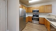 Located at 100 Chamberlain Dr in Asheville, NC, this well-appointed one-bedroom, one-bathroom home offers a thoughtfully designed layout with hardwood-style flooring throughout. The open kitchen features warm honey-toned cabinetry, light countertops, a stainless steel refrigerator, range, microwave, and dishwasher. A breakfast bar peninsula connects the kitchen to the main living area, making the space feel open and functional. The spacious living room is bright and airy, highlighted by French doors that lead to a private patio and fill the room with natural light. The generously sized bedroom includes a ceiling fan, a large window overlooking greenery, and light hardwood-style floors. The full bathroom offers a single-sink vanity with ample counter space, a tub-shower combo, and hardwood-style flooring. Storage is plentiful with four closets, including a walk-in closet outfitted with wire shelving. Additional conveniences include a dedicated laundry area and a utility room. Textured ceilings, neutral wall tones, and clean white trim complete the cohesive, move-in-ready aesthetic throughout the home.