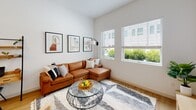 Located at 517 N Shipley St in Wilmington, Delaware, this single-floor residence offers a thoughtfully designed layout with a clean, modern aesthetic. The open-concept kitchen and living area serves as the heart of the home, featuring white flat-front cabinetry that extends to the ceiling, white quartz countertops, and a center island with an undermount sink. Stainless steel appliances — including a refrigerator, electric range, over-the-range microwave, and dishwasher — complete the well-appointed kitchen. Light wood-tone flooring flows throughout, adding warmth to the bright, white interior. The living area benefits from abundant natural light through large windows, creating an airy, open atmosphere. A dedicated nook accommodates a compact workspace, making the space as functional as it is comfortable. The bedroom is a calm retreat with a window overlooking the outdoors, light wood flooring, and clean white walls that complement the overall design language of the home. The bathroom is finished with large-format neutral tile flooring, a sleek white vanity with matte black hardware, a wall-length mirror, and a glass-enclosed walk-in shower with tile surround and matte black fixtures, delivering a spa-like feel. Throughout the space, consistent use of white tones, natural materials, and modern fixtures creates a cohesive, contemporary living environment.