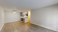 Located at 695 Normandy St in Houston, TX, this single-floor, 2-bedroom, 1-bathroom home offers a well-organized layout with thoughtfully updated finishes throughout. The open-concept living room flows seamlessly into the kitchen, creating a connected and functional common space. The living area features wood-look laminate flooring and a large window with a front door entry that allows natural light and greenery views to fill the room. The kitchen is a standout feature, showcasing gray shaker-style cabinetry, marble-look countertops, black appliances, and a galley-style layout that maximizes both counter and storage space. Both bedrooms are carpeted for comfort, each equipped with ceiling fans and windows that bring in natural light. The generously sized primary bedroom offers ample room for furnishings. A dedicated closet space includes built-in shelving and laundry hookups, providing practical utility storage. The bathroom is finished with a gray vanity that mirrors the kitchen cabinetry, a marble-look countertop, a combined tub and shower unit, and wood-look tile flooring, creating a cohesive aesthetic throughout the home. Neutral wall tones and consistent finishes give the entire space a clean, modern feel.