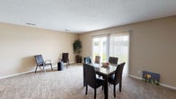 This single-story home offers a practical, well-organized layout across its main level. The open living and dining area is a notable feature, finished with neutral-toned carpet and warm beige walls throughout. A large sliding glass door floods the space with natural light and provides views of the outdoors, making it a bright and inviting area for everyday living. Textured ceilings are consistent throughout the home.

The kitchen is equipped with dark espresso-toned cabinetry, light granite-style countertops, wood-look flooring, and black appliances including an electric range and dishwasher, offering a clean, contrasting aesthetic. Ample cabinet space ensures strong storage functionality.

The bedrooms are generously proportioned, each featuring plush carpeting, neutral walls, and windows that allow natural light to filter in. The rooms provide flexible space suitable for a variety of configurations.

Two full bathrooms serve the home, each featuring a tiled tub-and-shower combination, a dark vanity with granite-style countertops, a white basin sink, and wood-look flooring. The layouts are efficient and cleanly finished.

Overall, the home presents a cohesive, neutral palette with consistent finishes throughout, offering a comfortable and functional living environment.