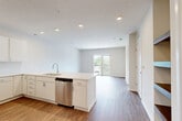 This well-appointed one-bedroom, one-bathroom unit at 2718 N 118th St in Omaha, Nebraska offers a thoughtfully designed open-concept layout. The combined kitchen and living area serves as the heart of the home, featuring rich hardwood-style flooring, recessed lighting, and a large peninsula with a crisp white countertop that provides both prep space and a natural divider between the kitchen and living areas. The kitchen is outfitted with white cabinetry, a stainless steel dishwasher, refrigerator, microwave, and range, creating a clean, modern aesthetic. Sliding glass doors lead from the living area to a private balcony, flooding the space with natural light and offering outdoor views. The bedroom is a comfortable retreat with soft carpeting, a ceiling fan, and a window overlooking the surrounding neighborhood. A dedicated walk-in closet with dual hanging rods provides generous storage. The bathroom is finished with wood-style flooring, a white vanity with ample cabinet storage, a well-lit mirror, and a full shower-tub combo. Throughout the unit, a neutral color palette and modern finishes create a bright, clean, and welcoming atmosphere.