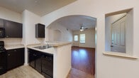 Located at 33168 Whipple Rd in Los Fresnos, TX, this single-story unit offers a well-designed layout with a clean, neutral aesthetic throughout. The living area welcomes you with rich wood-look flooring, a ceiling fan with light fixture, and natural light streaming through window blinds flanking the front entry door. Elegant arched doorways connect the living space to the kitchen and adjacent areas, adding a touch of architectural character to the open flow.

The kitchen is a standout feature, outfitted with dark espresso cabinetry, light stone-style countertops, and a full suite of black appliances including a refrigerator, range, microwave, and dishwasher. A peninsula with a built-in sink provides additional workspace and serves as a natural divider between the kitchen and living areas. Light wood-look flooring completes the kitchen's polished look.

The bedrooms continue the warm wood-look flooring and are generously sized, each equipped with ceiling fans and windows that invite natural light and outdoor views. The bathrooms feature tile flooring, dark vanity cabinetry, light countertops, and a tub-shower combination, offering a functional and tidy design. A hallway with a mirrored closet provides additional storage. The overall ambiance is bright, clean, and move-in ready.