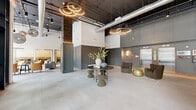 Located at 169 North Main Street in Port Chester, NY, this thoughtfully designed single-floor amenity space offers a seamless blend of industrial character and refined modern aesthetics across a generously proportioned footprint. The dramatic lobby sets the tone immediately, featuring soaring ceilings with exposed ductwork, a dark ceiling plane contrasted against crisp white upper walls, and elegant circular LED pendant fixtures. Light-toned large-format tile flooring flows throughout, anchoring the space with a clean, cohesive foundation. Sophisticated grey paneled walling adds architectural depth and a polished finish.

The great room opens to floor-to-ceiling curtain-wall glazing, flooding the interior with abundant natural light and offering direct views of the vibrant North Main Street streetscape. Thoughtfully curated seating arrangements with warm amber leather and neutral upholstery create inviting lounge areas beneath sculptural globe pendants. The adjacent family room provides a more intimate setting, complete with comfortable sofas, curated artwork, and refined paneled accent walls.

The kitchen features a substantial island with a stone-look countertop, decorative hexagonal tile flooring, open shelving adorned with greenery, and professional-grade appliances — making it well-suited for both everyday use and entertaining. Elevator access and additional utility areas round out the layout, delivering a complete and functional amenity experience.