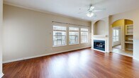 This two-story, two-bedroom, two-bathroom home in Mobile, Alabama offers a well-organized layout across two levels. The ground floor houses a private, attached garage with an automatic opener and clean concrete flooring, providing convenient parking and additional storage. A staircase leads to the main living level, where the majority of the home's living space is found.

The main level opens into a bright, generously sized living room featuring rich hardwood flooring, crown molding, a ceiling fan, multiple windows that flood the space with natural light, and a classic fireplace with a white mantle and built-in arched shelving. Adjacent to the living room, the kitchen is equipped with white cabinetry, granite-look countertops, a gas range, and tile flooring, offering a functional and attractive cooking space.

The primary bedroom is notably spacious, highlighted by a tray ceiling, a ceiling fan, plush carpeting, and a French door entry that brings in additional natural light. It includes a walk-in closet with wire shelving. The second bedroom also features carpet and a ceiling fan with a tray ceiling detail. Both bathrooms are finished with tile flooring, white vanity cabinetry, granite countertops, and a tub-shower combination, delivering a clean and cohesive aesthetic throughout.