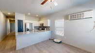 Located in Pueblo, Colorado, this well-designed 2-bedroom, 1-bathroom home makes smart use of its single-floor layout. The open-concept kitchen and living area serves as the heart of the home, featuring light wood-look flooring, a ceiling fan, and a wall-mounted mini-split unit for climate control. The kitchen is outfitted with white cabinetry, a gray-speckled granite-style countertop that extends into a breakfast bar, a subway tile backsplash, and a full suite of stainless steel appliances including a French door refrigerator and microwave. Natural light enters through a slatted blind-covered window, brightening the living space. The full bathroom offers a granite-topped vanity with white cabinetry, a tub-shower combination, and wood-look flooring, all accented by a bold slate-blue door. Both bedrooms feature plush carpet, ceiling fans, and individual wall-mounted PTAC heating and cooling units. The primary bedroom includes a spacious sliding double closet with distinctive blue paneled doors. A dedicated laundry area houses a stacked washer and dryer unit for added convenience. With four closets throughout, storage is plentiful in this thoughtfully laid-out home.