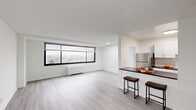 This well-appointed 2-bedroom, 1-bathroom residence at 4921 Seminary Rd in Alexandria, Virginia, offers a clean, modern aesthetic throughout. The open-concept living area is bathed in natural light from large picture windows that frame sweeping views of the surrounding Alexandria cityscape, creating a bright and airy atmosphere. Light gray wood-style flooring runs continuously throughout the unit, lending a cohesive and contemporary feel to every room.

The kitchen is efficiently designed with crisp white cabinetry, dark granite-style countertops, stainless steel appliances including a gas range, built-in microwave, dishwasher, and refrigerator. A peninsula with bar seating connects the kitchen to the living area, making it ideal for casual dining and entertaining.

Both bedrooms are generously sized with neutral white walls and large windows that continue the theme of natural light and outdoor views. The spacious primary bedroom offers a comfortable retreat with ample room for furnishings. The bathroom features a full tub-shower combination with clean white tile surround and chrome fixtures.

Throughout the residence, the minimalist design, neutral color palette, and consistent flooring create a polished, move-in-ready environment well-suited for modern urban living in Alexandria.