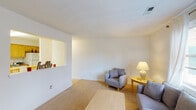 Located at 401 Westside Blvd NW in Roanoke, Virginia, this single-floor unit offers a straightforward, functional layout with clean, neutral finishes throughout. The living area is comfortably sized, featuring soft carpeted flooring, white walls, and windows dressed with sheer curtains that allow natural light to filter in and provide views of the surrounding neighborhood. A pass-through opening connects the living space to adjacent areas, adding a subtle sense of openness to the floor plan.

The kitchen is equipped with warm honey-toned wood cabinetry extending to the upper walls, providing generous storage. Dark countertops contrast with white appliances, including a range and dishwasher, while tile flooring adds a practical, easy-to-maintain surface underfoot.

The bedroom is a calm, well-proportioned space with carpeted floors, windows offering natural light and neighborhood views, and straightforward white walls that create a restful environment. An additional carpeted room with a double closet offers flexibility as a second bedroom or office.

The bathroom features a combined tub and shower with a curved curtain rod, a wood-cabinet vanity, and tile flooring, maintaining the unit's consistent, clean aesthetic. Overall, the space presents a practical and livable environment with a cohesive, understated design.