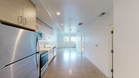 Located at 600 Ortiz Ave in Sand City, California, this thoughtfully designed one-bedroom, one-bathroom residence offers a clean, modern aesthetic across a single floor. The open-concept living and kitchen area is anchored by striking polished concrete floors that reflect natural light, creating a bright and airy atmosphere throughout the main living space. The kitchen is well-appointed with light wood cabinetry, white subway tile backsplash, stainless steel appliances including a refrigerator, electric range, built-in microwave, and dishwasher, all complemented by crisp white countertops. Recessed lighting illuminates the space efficiently. The bedroom features soft carpeting underfoot and a generously sized window framing views of the surrounding neighborhood and glimpses of the coastal landscape beyond — a standout feature of the room. A dedicated walk-in closet with built-in shelving and hanging rods provides practical storage. The bathroom is finished to a high standard, showcasing a frameless glass walk-in shower clad in white subway tile with mosaic tile flooring, a floating wood vanity with an integrated sink, a large mirror, and polished concrete floors that echo the main living area. The overall design is clean, contemporary, and cohesive throughout.