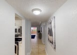 Located in Miami's 33156 zip code, this single-story residence offers a well-organized layout with a clean, contemporary aesthetic throughout. A tiled hallway connects the main living areas, with light-filled rooms and neutral gray walls creating a cohesive, modern feel.

The kitchen is outfitted with white shaker-style cabinetry, granite countertops, a stainless steel appliance suite including a range, microwave, and dishwasher, and tile flooring — combining functionality with a polished look.

The living area features large-format tile flooring and sliding glass doors that open to an outdoor patio, flooding the space with natural light and providing views of the surrounding greenery. A dedicated media wall adds a practical focal point to the room.

Two bedrooms feature rich hardwood flooring and large windows with vertical blinds that bring in ample natural light. The primary bedroom includes a generous closet, while both rooms offer comfortable proportions and a calm, restful atmosphere.

The bathrooms are finished with tile flooring and granite-topped vanities. One bathroom features a tub-shower combination with sliding glass doors and decorative tile accents, adding a touch of elegance. The overall design of the home is practical, bright, and well-suited to Miami's warm, vibrant lifestyle.