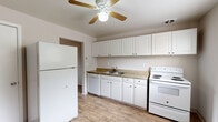 Located at 720 Melany Ln in Colorado Springs, Colorado, this single-story home offers a practical and well-organized floor plan designed for comfortable everyday living. The kitchen serves as a central functional space, outfitted with white cabinetry extending to the ceiling for ample storage, a double-basin sink, a full suite of white appliances including a refrigerator, dishwasher, and electric range, and warm-toned laminate countertops. A ceiling fan with built-in light provides ventilation and illumination throughout the kitchen. The light wood-style flooring in the kitchen carries a clean, cohesive aesthetic. Additional rooms feature plush carpeting, ceiling fans, and windows that allow natural light to filter in, creating a comfortable and airy feel. One room showcases wood-style flooring alongside a window-mounted air conditioning unit, offering flexible climate control. The bathroom includes a full tub-shower combination with white tile surround, maintaining a simple and functional design. The overall layout, as seen in the dollhouse view, is compact yet thoughtfully arranged, with clearly defined spaces flowing from the kitchen into the living and sleeping areas. This home provides a no-fuss, move-in-ready environment suited for a variety of lifestyles in the Colorado Springs area.