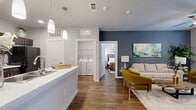 This thoughtfully designed 2-bedroom, 2-bathroom single-story residence offers a cohesive open-concept layout that seamlessly connects the kitchen, living, and dining areas. Rich hardwood-style flooring runs throughout, lending warmth and continuity to every room.

The kitchen is outfitted with dark espresso cabinetry, sleek white countertops, a tile backsplash, and a full suite of black appliances, including a range, microwave, dishwasher, and refrigerator. Pendant lighting adds a modern finishing touch above the counter space.

The living room is a standout area, featuring a bold slate-blue accent wall, a ceiling fan, and large windows with a glass door that invite natural light. The space offers a welcoming and stylish atmosphere ideal for relaxing or entertaining.

The primary bedroom is a comfortable retreat with hardwood-style flooring, a ceiling fan, and direct access to a dedicated closet and en-suite bathroom. The second bedroom is equally well-sized with its own closet access. Both bathrooms feature dark cabinetry, white countertops, and tiled tub-shower combinations.

A dedicated in-unit laundry room with a full-size washer and dryer and wire shelving above adds significant everyday convenience. Two closets provide ample storage throughout this efficiently designed and move-in-ready home.