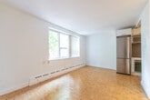 Located in the desirable Forest Hill neighbourhood of Toronto, this one-bedroom unit offers a well-organized layout across a single floor. The main living area is the heart of the space, finished with warm parquet wood flooring in a classic basket-weave pattern that extends throughout. A large window with vertical blinds fills the room with natural light and frames a leafy outdoor view, creating a bright and inviting atmosphere. A baseboard heating system runs along the perimeter, ensuring year-round comfort.

The kitchen is efficiently designed with white cabinetry, a dark tile backsplash, and a full suite of stainless steel appliances including a refrigerator, oven, and built-in microwave. It connects seamlessly to the entry corridor, which features a sliding-door closet and direct access to a bathroom. The bedroom is a clean, quiet space with the same parquet flooring, white walls, and access to the bathroom, offering a functional and restful retreat. The overall aesthetic is clean and minimal, with white walls and crisp trim throughout, making the space feel open and easy to personalize.