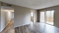 Located at 105 Cavalier Dr in Greenville, SC, this single-story home offers three bedrooms and two bathrooms across a well-organized floor plan. Warm-toned, wood-look flooring runs throughout the living areas and bedrooms, providing a cohesive and low-maintenance aesthetic. Neutral taupe walls complement the flooring and create a clean, consistent palette across all rooms.

The living room is generously proportioned, featuring a textured ceiling and a sliding glass door fitted with vertical blinds that allows natural light to fill the space. The galley-style kitchen is efficiently laid out with white cabinetry, white countertops, a stainless steel refrigerator, and an electric range. A skylight overhead brightens the kitchen with additional natural light.

The spacious primary bedroom offers ample room and connects to the rest of the home via a central hallway. Two additional bedrooms each include closets with bi-fold doors, providing practical storage. The bathrooms feature tub-shower combinations with clean white tile surrounds.

Two closets throughout the home offer supplemental storage, and the layout flows logically from the living and kitchen areas through the hallway to the bedrooms. The textured ceilings and consistent finishes throughout give the home a tidy, updated appearance well-suited for comfortable everyday living.