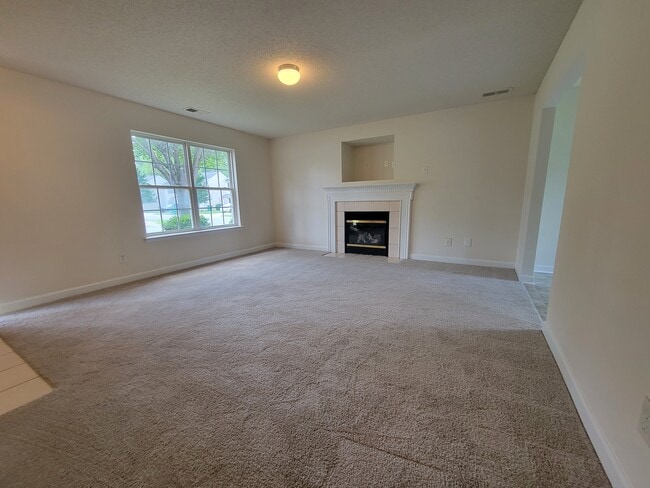 Spacious living room with a gas fireplace and built-ins for a television. - 6903 Seney Dr