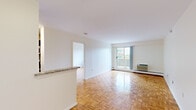 Located on the 8th floor at 175 Freeman St in Brookline, MA, this 2-bedroom, 2-bathroom unit offers a well-organized single-floor layout filled with natural light. The open living room is anchored by classic parquet flooring that runs throughout the unit and features a sliding glass door leading to a private balcony with tree-lined outdoor views. The kitchen is thoughtfully appointed with dark espresso cabinetry, granite countertops, stainless steel appliances including a refrigerator and dishwasher, and tile flooring — separated from the living area by a half-wall breakfast bar. The spacious primary bedroom includes a large closet and direct access to a full bathroom featuring a rich wood vanity, tub-shower combo, and tile flooring. The second bedroom is generously sized with its own window overlooking greenery, parquet flooring, and ample wall space. A second bathroom offers a clean, minimalist design with a wall-mounted mirror and white fixtures. Throughout the unit, bright white walls and natural light from multiple windows create a clean, airy ambiance well-suited to comfortable urban living in the heart of Brookline.