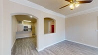 Located on Champlin Drive in Little Rock, Arkansas, this single-story home offers a well-designed, functional layout with a warm, neutral color palette throughout. The living areas feature light-toned luxury vinyl plank flooring and are accented by crown molding and ceiling fans. Elegant arched doorways connect the main living space to the kitchen and adjoining rooms, adding architectural character to the open floor plan. Natural light filters through blinds-fitted windows, enhancing the bright and airy ambiance.

The kitchen is equipped with stainless steel appliances, including a range, microwave, and dishwasher, complemented by granite countertops, white cabinetry, a subway tile backsplash, and a double-basin sink. A convenient pass-through bar connects the kitchen to the adjacent dining or living area. The kitchen also provides direct access to an in-unit laundry area.

The bedrooms are carpeted for comfort and each include ceiling fans and access to closet space. At least one bedroom features a spacious walk-in closet outfitted with wire shelving on multiple walls, offering generous storage. The bathroom includes a soaking tub and shower combination with white tile surround and chrome grab bars. A back door with glass panels leads to the exterior, completing this practical and comfortable home.