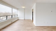This 710 square foot apartment offers a well-designed living space with a focus on modern amenities and natural light. The single-floor layout comprises one bedroom, one bathroom, a living room, kitchen, utility room, and hallway. The primary bedroom, measuring 140 square feet, provides ample space for rest and relaxation.

The kitchen is a standout feature, showcasing a galley-style design with white cabinetry, subway tile backsplash, and stainless steel appliances. It offers plenty of counter space and storage, making it both functional and aesthetically pleasing. The living area is generously sized, with large windows that flood the space with natural light and offer views of the surrounding cityscape.

Throughout the apartment, light-toned wood-look flooring creates a cohesive and contemporary feel. The bathroom features a clean, modern design with white subway tiles and a full-sized bathtub. Built-in closets in the bedroom provide excellent storage solutions.

High ceilings and an open-concept design contribute to the apartment's spacious feel. The neutral color palette and minimalist design elements create a blank canvas for personal styling. Located at 560 Proudfoot Ln in London, Ontario, this apartment combines urban living with comfortable, updated interiors.