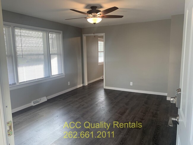 Living room with large window and ceiling fan. Approx. room size: 15' x 11.5' - 1398 N Rd