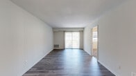 Located at 5703 Cedonia Ave in Baltimore, MD, this single-floor home offers four bedrooms and two bathrooms within a practical and well-organized layout. The living room serves as the heart of the home, featuring rich dark hardwood-style flooring that reflects natural light pouring in through large sliding glass doors. The open feel of this space makes it ideal for both relaxing and entertaining.

The kitchen is efficiently designed and includes a gas range, white refrigerator, and classic white tile backsplash, complemented by hardwood-style flooring that ties the space together. The four bedrooms vary in character: the primary bedroom is generously sized, featuring warm wood-tone flooring and a walk-in closet with built-in shelving, while additional bedrooms are carpeted for added comfort and include ample natural light from well-positioned windows.

Both bathrooms are functional and clean in design. A dedicated laundry room adds everyday convenience with a stacked washer and dryer unit already in place. Multiple hallways connect the rooms smoothly throughout the home, contributing to an efficient flow. Neutral wall tones throughout create a clean, move-in-ready aesthetic well-suited for a variety of furnishing styles.