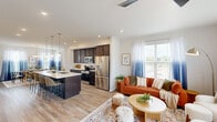 This well-designed three-story home on Summit Dr in Barboursville, VA offers a thoughtful layout across three distinct floors, providing generous living space and functional versatility. The main level opens to a bright, open-concept living, dining, and kitchen area with luxury vinyl plank flooring throughout. The modern kitchen features dark espresso cabinetry, stainless steel appliances, a large center island with a quartz countertop and bar seating, and stylish pendant lighting — all flowing seamlessly into the dining area and adjacent living room. The dining space is anchored by an elegant chandelier and bathed in natural light from large windows with sheer draping curtains. An inviting entrance and additional living room round out the lower floor. Upstairs, the home includes three well-appointed bedrooms, highlighted by a spacious primary suite. The carpeted bedrooms offer natural light through ample windows, while the bathrooms feature clean, contemporary finishes including a double-sink vanity with quartz countertops. A dedicated office with corner windows and plentiful natural light provides an ideal work-from-home space. The top floor living room opens to a private balcony, offering outdoor views and additional entertaining space. With four bathrooms, multiple staircases, and a closet, this home delivers both comfort and practicality.