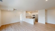 Located in Georgetown, Delaware, this single-floor, two-bedroom, two-bathroom residence offers a thoughtfully designed layout with modern finishes throughout. The open-concept kitchen and living area serves as the heart of the home, featuring white shaker-style upper cabinets, gray lower cabinetry, a classic subway tile backsplash, light quartz countertops, a peninsula with seating, and a full suite of stainless steel appliances. Light hardwood-style flooring runs throughout the main living spaces, enhancing the bright and airy ambiance created by recessed lighting. The spacious living area is highlighted by sliding glass doors that open onto a private balcony, flooding the room with natural light. Both bedrooms are carpeted for comfort, with large windows and ample closet space — five closets in total are distributed throughout the home. The primary bedroom includes a ceiling fan and generous proportions. The two bathrooms feature gray vanity cabinetry with white countertops and well-lit mirrors. A dedicated laundry area and a connecting hallway round out the functional floor plan. The clean, neutral palette and modern finishes create a cohesive and move-in-ready living environment.