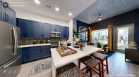 Located at 313 Liggett St in Durham, NC, this one-bedroom, one-bathroom unit offers a thoughtfully designed single-floor layout with a cohesive, modern aesthetic. The kitchen is a standout feature, showcasing bold navy shaker-style cabinetry, a striking black hexagonal tile backsplash, and a large quartz waterfall island with an undermount sink—ideal for both meal prep and casual dining. Stainless steel appliances, including a French door refrigerator, over-the-range microwave, and gas range, complete the well-equipped cooking space. Light wood-style flooring runs throughout, tying the open-concept living and kitchen areas together. Exposed concrete ceiling and wall elements lend an industrial edge that contrasts beautifully with the navy and white palette. The bedroom continues the deep navy color scheme, with a large window inviting natural light and views of the surrounding greenery. The bathroom mirrors the kitchen's design language with navy cabinetry, a white quartz vanity top, large-format tile, and a framed mirror. The unit also includes two closets and a dedicated laundry area, providing practical storage solutions. The overall ambiance is bold, curated, and urban.