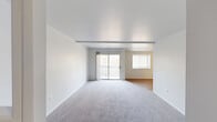 This well-appointed one-bedroom, one-bathroom residence in Matawan, NJ offers a thoughtfully designed single-floor layout. The open-concept living and dining area is bathed in natural light, featuring neutral carpet, clean white walls, and a sliding glass door that leads to a private balcony with outdoor views. The adjacent dining area transitions seamlessly into the kitchen, which is finished with warm hardwood-style flooring, white shaker cabinets, granite countertops, and stainless steel appliances including a range, refrigerator, and dishwasher. A dedicated laundry area with a stacked washer-dryer unit adds everyday convenience. The spacious bedroom is a standout feature, boasting vaulted ceilings, multiple windows that invite generous natural light, soft carpet flooring, and a closet. Two additional closets throughout the unit provide ample storage. The full bathroom is cleanly finished with wood-look tile flooring, a tub-shower combination, a vanity with storage, and bright white walls. A hallway connects all areas of the home cohesively. The overall ambiance is bright, clean, and functional, making this an ideal space in a convenient New Jersey location.