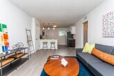 Located at 1073 Woodland Ave NE in Atlanta, GA, this single-floor residence offers a well-designed layout with a cohesive, contemporary aesthetic. The kitchen serves as a functional centerpiece, showcasing two-tone cabinetry with crisp white upper cabinets and dark lower cabinets, a classic white subway tile backsplash, white countertops, and stainless steel appliances including a range and over-the-range microwave. A peninsula with bar seating provides a casual dining option and connects seamlessly to the surrounding living areas. The living room is bright and inviting, benefiting from natural light through plantation-shuttered windows and featuring durable wood-look flooring that extends throughout the home. The bedrooms are generously proportioned, with multiple windows allowing ample natural light to fill each room. One bedroom includes a ceiling fan and a closet with built-in shelving, while another features views of surrounding greenery. The bathroom presents a clean, all-white design with a single vanity, tub-shower combination, and wood-look flooring. Clean white walls, consistent flooring, and thoughtful layouts unify the space, creating a bright and functional home in a convenient Atlanta neighborhood.