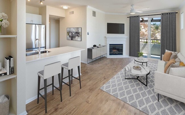 Renovated Package IU kitchen and living room area with open concept floor plan, fireplace, and hard surface flooring - Avalon Simi Valley