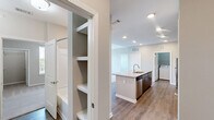 Located at 6854 Governors West NW in Huntsville, Alabama, this well-appointed two-bedroom, two-bathroom residence offers a thoughtfully designed single-level layout. The kitchen serves as the heart of the home, showcasing rich dark-wood cabinetry, granite countertops, a large center island with a built-in sink, subway tile backsplash, and stainless steel appliances including a refrigerator, range, and microwave. Wood-look flooring flows throughout the main living and kitchen areas, adding warmth and continuity to the space. The primary bedroom features a tray ceiling with a ceiling fan, natural light from large windows with outdoor views, and direct access to a well-appointed en-suite bathroom complete with granite vanity, dark cabinetry, and a walk-in closet with built-in shelving. The second bedroom also benefits from a ceiling fan, plush carpeting, a walk-in closet, and bright window views. Both bathrooms are finished with wood-look flooring and clean, neutral tones. A dedicated laundry room provides added convenience with in-unit washer and dryer hookups. Neutral wall colors and consistent finishes throughout give the home a cohesive and move-in-ready appeal.