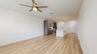 Located at 101 Mirano Way in Nokomis, Florida, this well-appointed 1-bedroom, 1-bathroom residence offers a thoughtfully designed open-concept layout with modern finishes throughout. Light-toned luxury vinyl plank flooring runs continuously across the living areas, enhancing the sense of openness and ease of movement between spaces.

The kitchen is a standout feature, showcasing gray shaker-style cabinetry, crisp white quartz countertops, and a suite of stainless steel appliances including a range, microwave, and refrigerator. A central island with an undermount sink and stylish pendant lighting above serves as both a functional workspace and a natural gathering point that flows seamlessly into the living room.

The living room is bright and airy, benefiting from natural light and a ceiling fan overhead. A balcony access door and multiple windows offer views of the surrounding community. The bedroom is a comfortable, well-lit retreat with windows providing natural light, a ceiling fan, and direct access to both a closet and the full bathroom. The bathroom features dark vanity cabinetry complementing the home's overall design palette.

A dedicated closet provides practical storage, and the clean, neutral color scheme throughout creates a versatile and inviting atmosphere ideal for modern living.