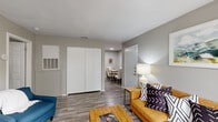 Located at 3549 Curry Ln in Abilene, TX, this one-bedroom, two-bathroom home offers a well-designed single-floor layout with wood-look flooring carried consistently throughout. The living room serves as the heart of the home, anchored by a tile-surround fireplace, recessed lighting, and a sliding glass door that opens to a private balcony, bringing in natural light and outdoor access. The galley-style kitchen is efficiently organized with white cabinetry, speckled countertops, black appliances including a range and dishwasher, and a dedicated laundry area at the rear. Adjacent to the kitchen, the dining area provides a defined space for meals, accented by neutral walls and a wall-mounted shelf. The bedroom is a comfortable retreat featuring a ceiling fan, natural light from a window with blinds, and access to two closets. Two full bathrooms serve the home, each finished with wood-look flooring and clean, neutral finishes. Two generous closets offer practical storage throughout the unit. The overall aesthetic is clean and contemporary, with a neutral gray palette, textured ceilings, and a cohesive design that makes efficient use of every square foot.
