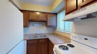 Located at 6592 Steinway Dr in Reynoldsburg, Ohio, this two-floor home offers a practical and comfortable layout across its two levels. The kitchen is equipped with rich wood cabinetry, laminate countertops, a double-basin sink, a coil-burner electric range with an overhead exhaust hood, and a dishwasher. A window with blinds allows natural light to brighten the cooking area. The main living area is generously sized, featuring neutral-toned carpet, beige walls, and a sliding glass door fitted with vertical blinds that floods the room with natural light. A structural column adds a subtle architectural detail to this open space. The upper level includes a spacious primary bedroom with a sliding door closet and its own sliding glass door for additional natural light. Additional bedrooms are carpeted, with windows and ample room for furnishings. The bathroom features tile flooring and a sloped ceiling that adds character to the space. A lower level provides additional living or flex space, complete with carpet, a textured ceiling, and a pass-through opening to the kitchen cabinetry above. Throughout, the home maintains a clean, neutral palette with consistent finishes, making it a versatile and move-in ready residence.