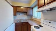 Located at 6592 Steinway Dr in Reynoldsburg, Ohio, this two-floor home offers a practical and comfortable layout across its two levels. The kitchen is equipped with rich wood cabinetry, laminate countertops, a double-basin sink, a coil-burner electric range with an overhead exhaust hood, and a dishwasher. A window with blinds allows natural light to brighten the cooking area. The main living area is generously sized, featuring neutral-toned carpet, beige walls, and a sliding glass door fitted with vertical blinds that floods the room with natural light. A structural column adds a subtle architectural detail to this open space. The upper level includes a spacious primary bedroom with a sliding door closet and its own sliding glass door for additional natural light. Additional bedrooms are carpeted, with windows and ample room for furnishings. The bathroom features tile flooring and a sloped ceiling that adds character to the space. A lower level provides additional living or flex space, complete with carpet, a textured ceiling, and a pass-through opening to the kitchen cabinetry above. Throughout, the home maintains a clean, neutral palette with consistent finishes, making it a versatile and move-in ready residence.