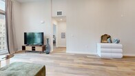 Located at 748 Irolo St in Los Angeles, this thoughtfully designed 2-bedroom, 2-bathroom unit offers a clean, modern aesthetic throughout its well-appointed single-floor layout. Light wood-style flooring flows consistently across all rooms, complementing the bright, neutral color palette that defines the space.

The living room stands out with notably high ceilings that amplify the sense of openness, and large floor-to-ceiling sliding glass doors lead to a private balcony overlooking the surrounding cityscape and greenery. This area transitions naturally toward the kitchen and hallways.

The kitchen is efficiently laid out with ample grey shaker-style cabinetry, white quartz countertops, a white subway tile backsplash, and stainless steel appliances including a refrigerator and dishwasher, providing both functionality and style.

The primary bedroom features elevated ceilings, a dedicated closet, and direct access to one of the two bathrooms. The second bedroom also benefits from high ceilings and generous natural light from large windows. Both bathrooms are finished with grey shaker vanities, white quartz countertops, backlit mirrors, and tub-shower combinations, maintaining a consistent modern design throughout the unit.