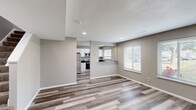 Located at 4000 Archer Dr in East Moline, IL, this two-story, 3-bedroom, 2-bathroom home offers a practical and modern layout spread across two floors. The main level features an open-concept living area with wood-look laminate flooring, neutral gray walls, and a textured ceiling. Recessed lighting and white-slat window blinds allow natural light to fill the space, creating a bright and welcoming atmosphere.

The kitchen is a standout feature, boasting crisp white shaker-style cabinetry, dark granite countertops, and a full suite of stainless steel appliances including a refrigerator, electric range, over-the-range microwave, and dishwasher. A peninsula with a dark granite overhang connects the kitchen to the living area, ideal for casual dining or entertaining.

Upstairs, three bedrooms continue the wood-look flooring and neutral color palette. Each room includes windows with outdoor views and ample closet space — with five closets distributed throughout the home. The primary bedroom features a ceiling fan for added comfort. The two bathrooms are clean and functional, with white vanities and chrome fixtures. Additional utility and laundry rooms provide convenient in-home functionality. Overall, the space presents a well-organized, move-in-ready home with consistent modern finishes throughout.